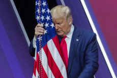 Il Presidente Donald J. Trump abbraccia la bandiera americana alla 47/esima Conservative Political Action Conference (CPAC) in Maryland