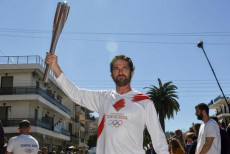 L'attore Gerard Butler posa con la torcia olimpica in Sparta,