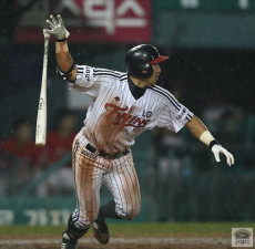Un battitore dei Twins di Corea del Sud lancia la mazza corre ver la prima base.