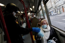 Distribuzione di mascherine su un bus in Spagna.