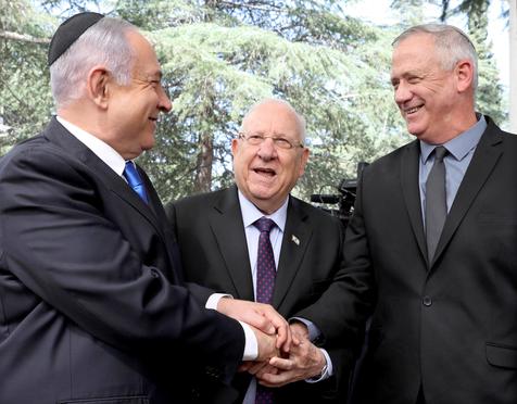 Il primo ministro d'Israele Benjamin Netanyahu (S) stringe la mano di Benny Gantz (D) con chi condivideva il governo. Al centro, il presidente d'Israele Reuven Rivlin.