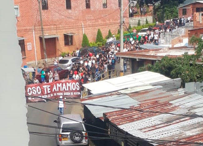 Una folla trasporta la bara del criminale detto "Oso" ed uno striscione con la scritta "Oso ti amiamo" nella localitá di Bello in Colombia.