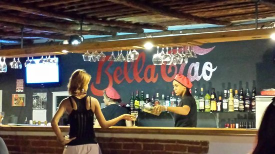 Una bartender serve un drink a una cliente nel restaurante "Bella Ciao" dell'Avana,Cuba.