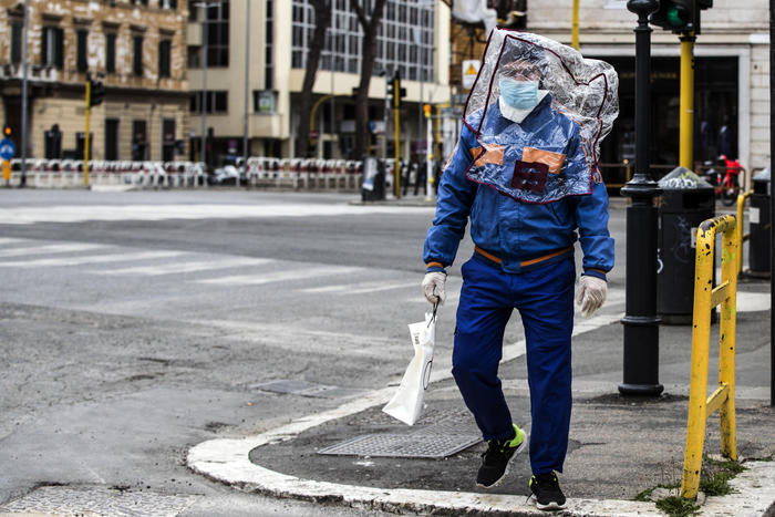 Un uomo a Roma in giro con una busta di plastica in testa e la mascherina..