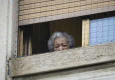 Una anziana affacciata all'istituto Palazzolo Don Gnocchi di Milano.
