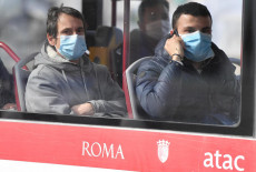 Due passeggeri con mascherine in un autobus a Roma