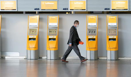 Un passeggero con mascherina cammina nell'aeroporto di Francoforte, Germania. (ANSA/EPA/THORSTEN WAGNER)
