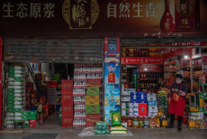 Un venditore aspetta per clienti in un negozio aperto a Wuhan, Cina.