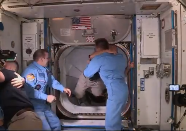 Lo storico abbraccio dell'equipaggio della Crew Dragon con quello della Stazione Spaziale (fonte: NASA TV)