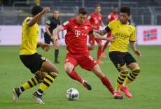 Robert Lewandowski (C) del Bayern Munich tra due rivali del Borussia Dortmund.