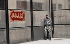 Un guardia sorveglia la porta del carcere di Tora al Cairo, dove é deceduto el dissidente Shady Habash.