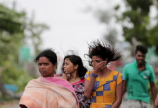 Cittadine indiane evacuate camminano verso la scuola, prima dell'arrivo del Ciclone Amphan nel villaggio di Balikhali vicino alla Bahia di Bengala India,
