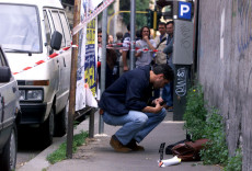 Una foto di archivio del 20 Maggio 1999 di un inquirente che osserva la borsa di Massimo D' Antona sul luogo del delittto