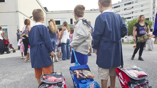 Bambini a scuola con il grembiule azzurro.