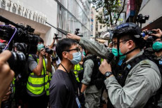 Un poliziotto sostiene per i capelli ad un manifestante a Hong Kong.