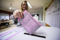 Una signora introduce il proprio voto nell'urna elettorale