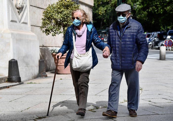 Due anziani con la mascherina in giro per la città. L'utilizzo delle mascherine è obbligatorio.