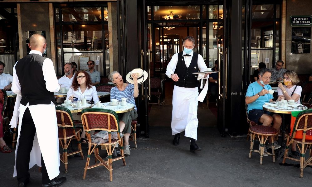 Un caffé con tavolini all'aperto ,a Parigi.