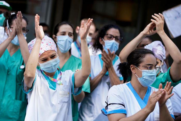 Infermieri e personale medico applaudono in protesta nell'ospedale Joseph Bracops a Bruxelles.