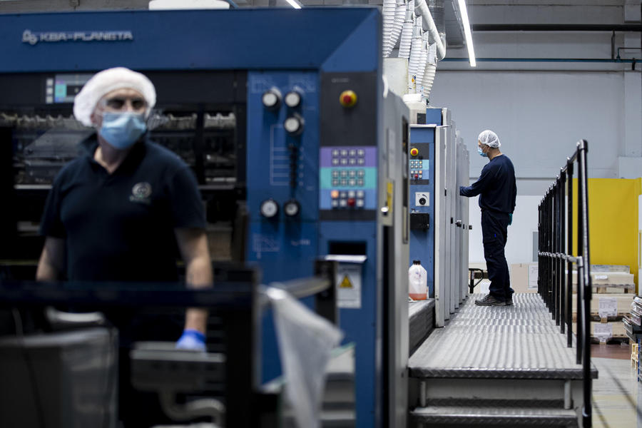 Dipendenti indossano mascherine e guanti protettivi a prevenzione della diffusione del Covid-19, durante il turno di lavoro, presso lo stabilimento industriale di packaging farmaceutico Eurpack di Aprilia