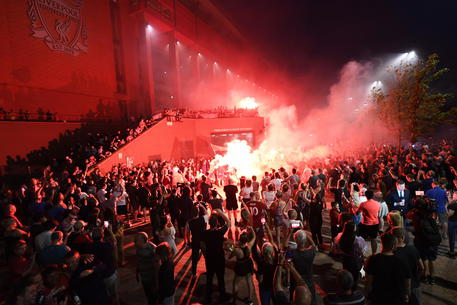 MIgliaia di tifosi celebrano con fuochi d'artificio e canti lo scudetto dei "Reds" davanti allo stadio Anfield di Liverpool.
