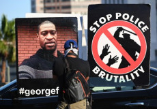 Un cartellone con la scritta: Stop alla brutalitá della polizia" ed un altro con l'immagine di George Floyd, morto durante un arresto a Minneapolis.