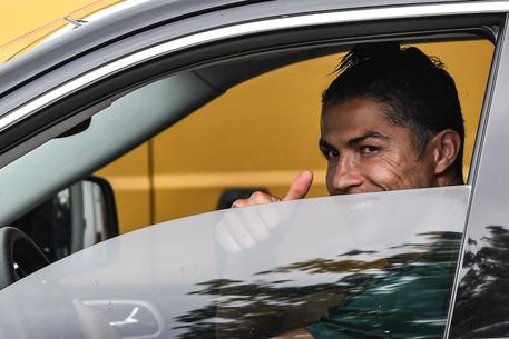 Cristiano Ronaldo saluta dal finestrino della sua auto all'uscita della Continassa.