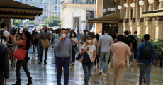 Offerte e saldi per invogliare le spese con diverse code fuori dai negozi di abbigliamento di Milano