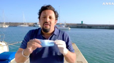 Frame video Ansa dello spot protagonizzato da Enrico Brignano sull'uso delle mascherine e guanti.