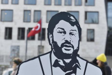 Un cartellone con la figura ritagliata di Taner Kilic portata da manifestanti durante una protesta di Amnesty International per la sua liberazione.