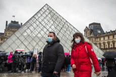 Visitanti con mascherine davanti alla Piramide nel Museo del Louvre a Parigi. EPA/CH