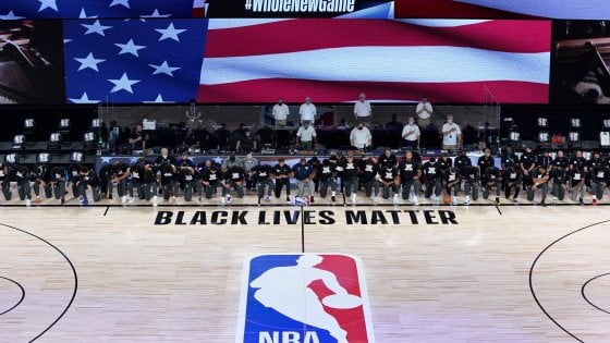 Giocatori, allenatori e arbitri in ginocchio a sostegno della lotta antirazzista del movimento "Black lives matter", all'inizio del capio0nato della Nba a Orlando, Usa.