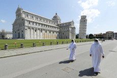 Due suore passeggiano in Piazza dei Miracoli a Pisa.