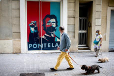 Un graffiti dipinto su un muro a Barcellona ricorda ai cittadini di indossare la mscherina.