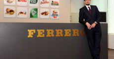 L'imprenditore Giovanni Ferrero davanti al logo della sua marca.