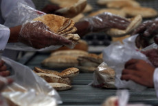 Yemeniti con guanti lavorano in una pasticceria in Sana'a, Yemen.
