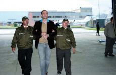 L'ex comandante paramilitare italo-colombiano Salvatore Mancuso,in manette, tra due agenti della polizia. Immagine d'archivio.