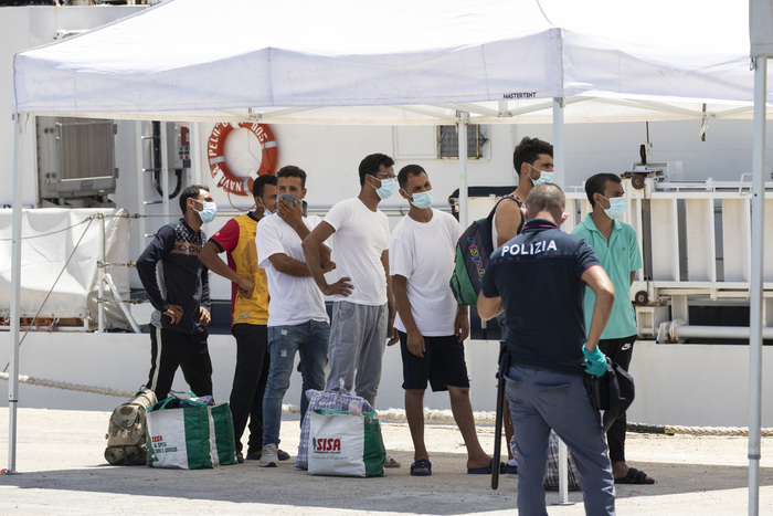 Migranti a Lampedusa in attesa del test Covid.