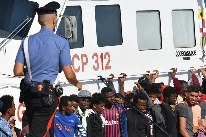 Migranti a bordo di un'unità della Guardia Costiera attracca a Lampedusa.