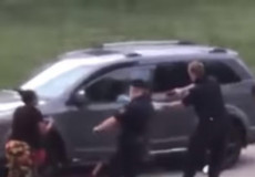 Fermo immagine di un video ripreso con un telefonino di un agente che spara alla schiena ad un afromericano.