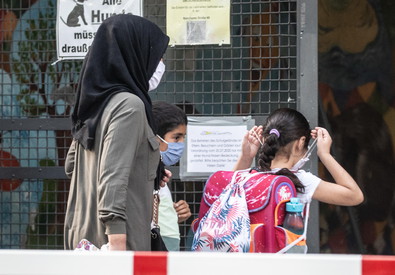 Bambini con mascherine all'ingresso di una scuola a Berlino.