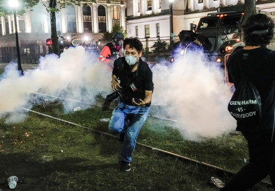 Manifestanti scappano dalle bombre lacrimogene durante proteste a Kenosha, Wisconsin.