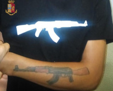 Nella foto fornita dalla Polizia di Stato il tatuaggio sul braccio di un AK-47.