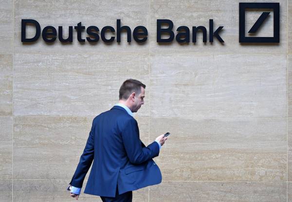 Un uomo passa davanti ad una agenzia del Deutsche Bank a Londra.