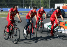 Charles Leclec (al centro) in bicicleta con membri del team Ferrari.