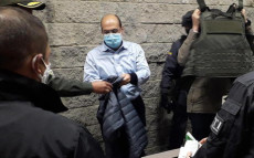 L'ex capo paramilitare Rodrigo Tovar Pupo (C), alias Jorge 40, custodiato da agenti della sicurezza, arriva all'ufficio della Procura di Bogotá.