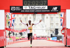 Il keniano Eliud Kipchoge esulta mentre taglia il traguardo della maratona di Londra 2019.