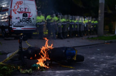 Una moto in fiamme davanti un picchetto della polizia in Bogotá.