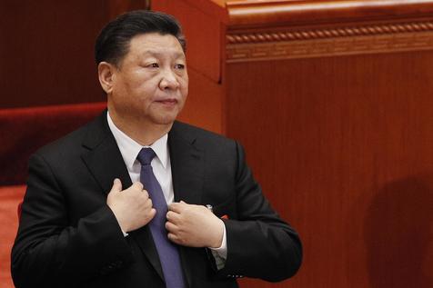 Il presidente cinese Xi Jinping si sistema la giacca al suo ingresso nella sessione plenaria del Congresso nella Grande Sala del Popolo a Pechino. (ANSA/AP/Andy Wong)