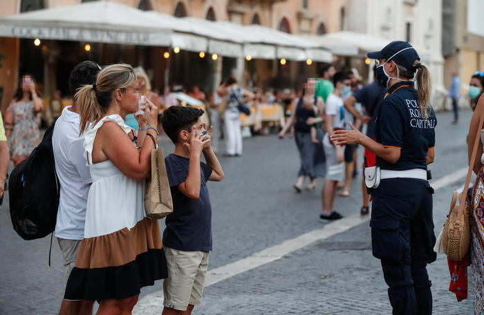 Polizia controlla che tutti indossino le mascherine a Piazza Navona, Roma.